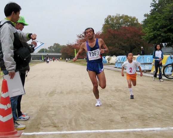 ハーフの部出場で折返しの松本明選手と小学生1Kmの部でゴール寸前の狭間海人くん ハーフの部出場で折返しの松本明選手と小学生1Kmの部でゴール寸前の狭間海人くん